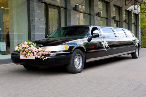 A black stretched limo with flowers.